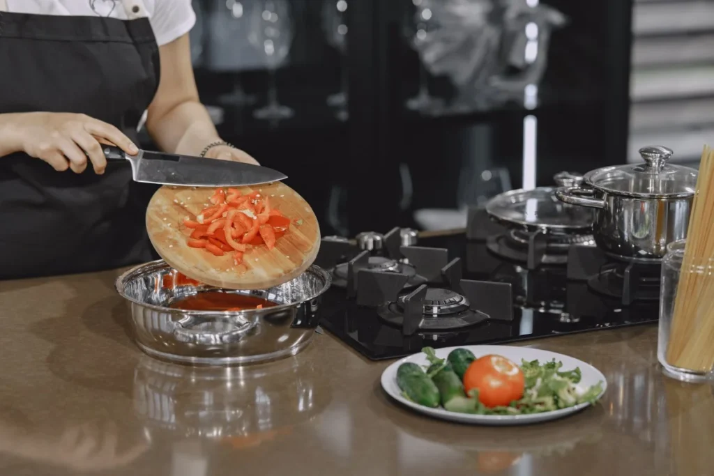 まな板の上で切られた野菜。自炊で食事を整えるイメージ